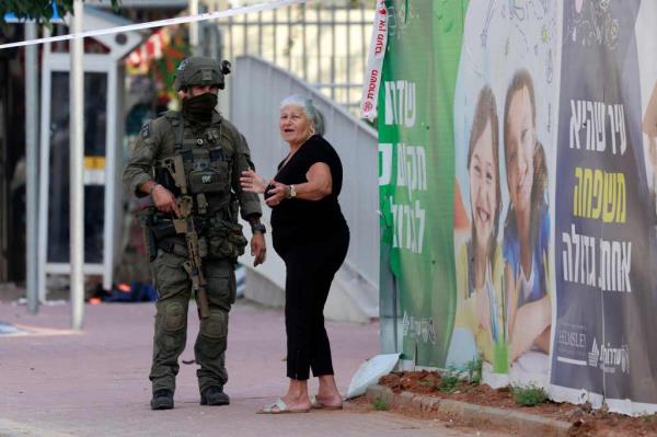 A resident stands with an Israeli soldier near a closed off area on Sunday. 