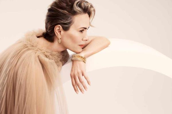 Sarah Paulson in a dress and red shoes.