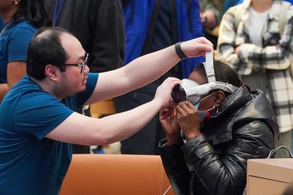 Apple Store worker adjusts the straps of the Vision Pro headset on the head of NY Post reporter, Georgett Roberts 