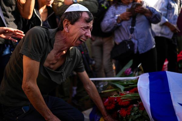 A man mourns during the funeral of one of the Israeli victims slaughtered attending the music festival in southern Israel. 