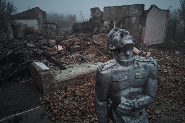 A statue of a Soviet soldier against the background of a house of culture destroyed by rocket fire on the outskirts of Avdiivka.