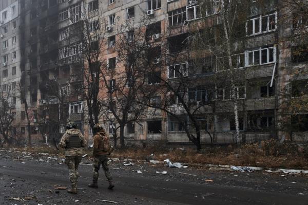 Two Ukrainian soldiers walk along the destroyed city of Avdiivka. 