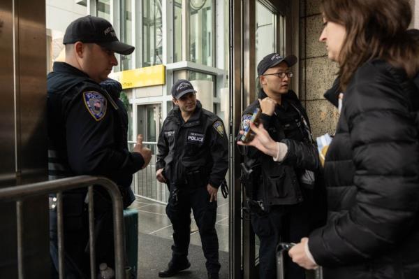 Travelers wait in line to show boarding pass to enter Jamaica Airtrain station