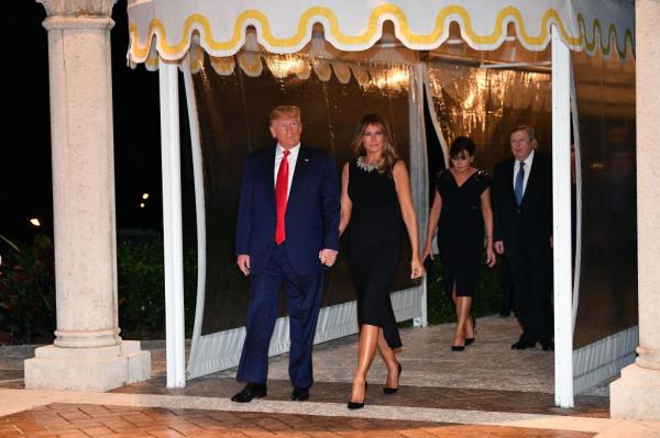US President Do<em></em>nald Trump and First Lady Melania Trump arrive for a Christmas Eve dinner with his family, followed by First Lady's parents Viktor Knavs and Amalija Knavs, at Mar-A-Lago in Palm Beach, Florid