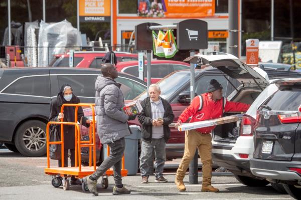 Migrant approaches shopper putting boxes in his car in the parking lot of the Home Depot in Throggs Neck, The Bronx