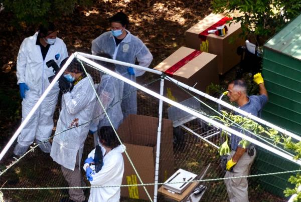 A photo of cops at Rex Heuermann's house.