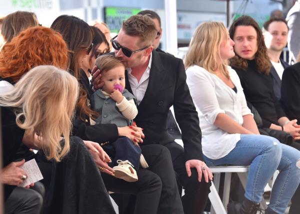 Culkin plants a sweet kiss on his son Dakota at his Hollywood Walk of Fame ceremony.