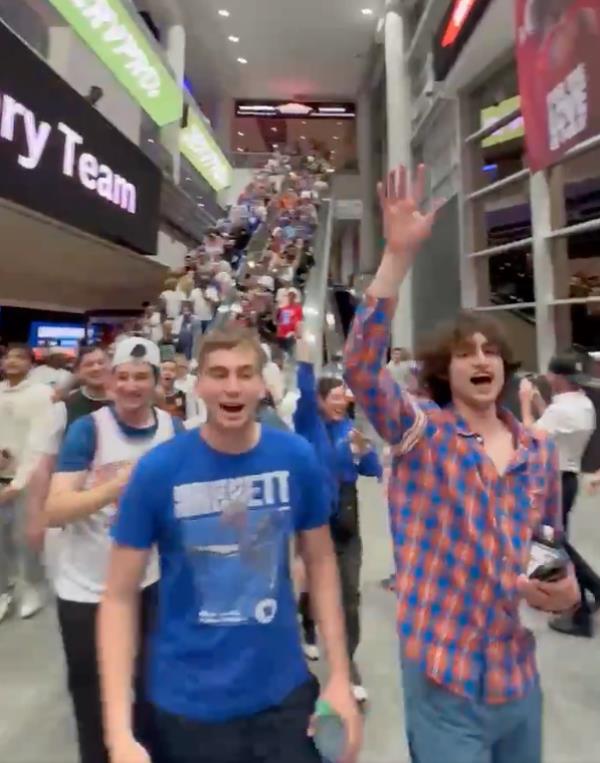 A group of people standing in aKnicks fans go wild after the team's Game 6 win over the 76ers on May 2, 2024.  building with a staircase