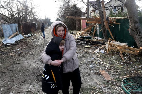 A woman and a child standing amid debris following the Russian attack.