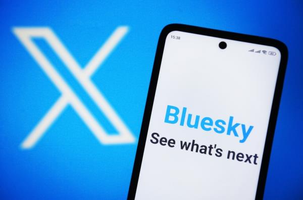 Bluesky Social logo displayed on a smartphone screen with rebranded Twitter logo as X Corp in the background