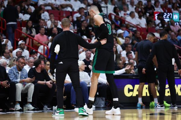 Kristaps Porzingis #8 of the Boston Celtics leaves the game against the Miami Heat during the second quarter after suffering an apparent injury