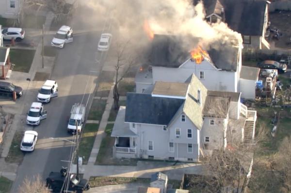 House on fire with cars on the side.
