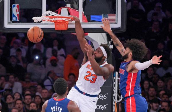 Mitchell Robinson #23 slams the ball over Detroit Pistons center Jalen Duren #0 during the second quarter