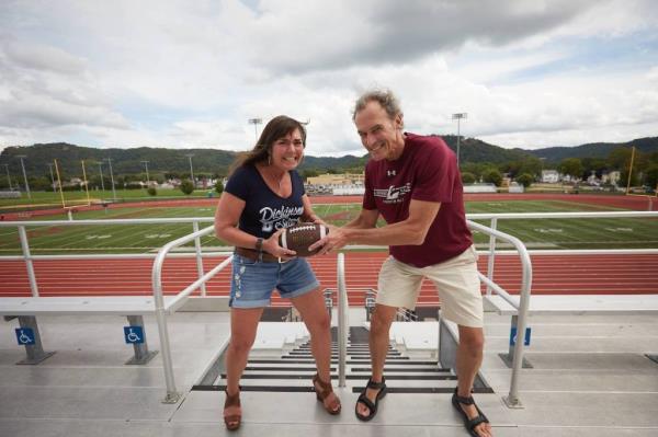 Joe Gow and Carmen Wilson both grab a football.