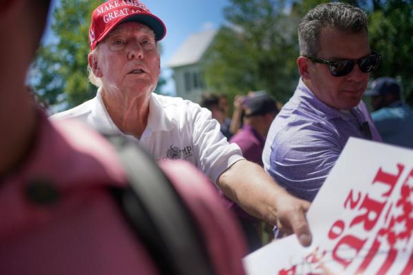 Former President Do<em></em>nald Trump signs autographs before the start of the final round of the Bedminster Invitatio<em></em>nal LIV Golf tournament in Bedminster, N.J., Sunday, Aug. 13, 2023.