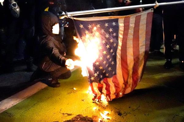A protester lights an American flag on fire during a demo<em></em>nstration Wednesday, Nov. 4, 2020, in Portland, Oregon.