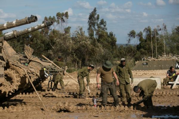 Israeli soldiers fix a tank's tracks as they co<em></em>ntinue their advancement in Gaza.