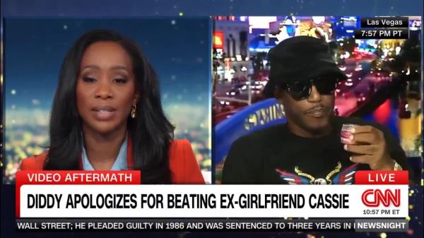Rapper Cam'ron sipping his supplement PinkHorsePower during a news show, expressing displeasure at being asked a<em></em>bout Diddy by a CNN reporter.