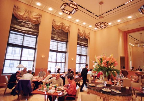 Luxurious penthouse suite in the Four Seasons Hotel, New York City, featuring a piano and a large window overlooking the city