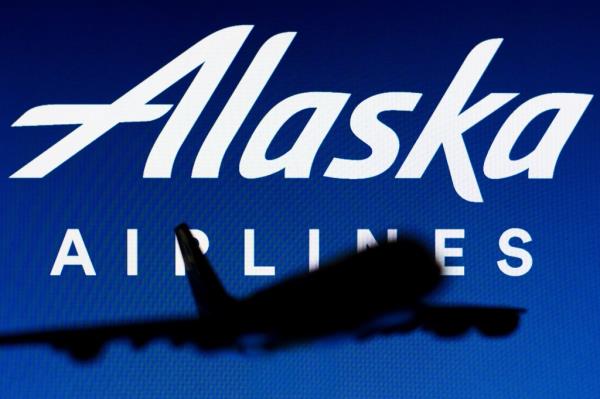 The Alaska Airlines logo is seen in the background of a silhouette of an Airbus A380 plane