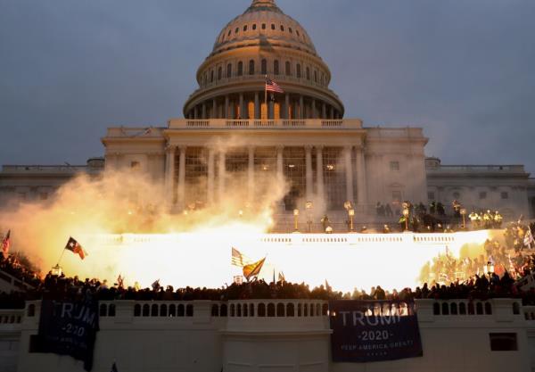 The grounds of the Capitol brightly illuminated among thro<em></em>ngs of rioters.