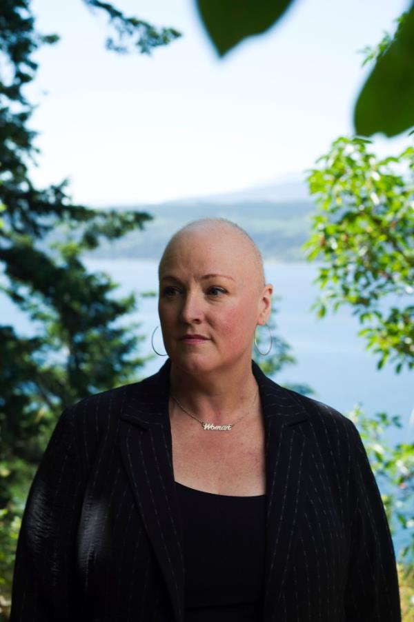 Amy Sousa, a woman with a shaved head, standing in Port Townsend, WA