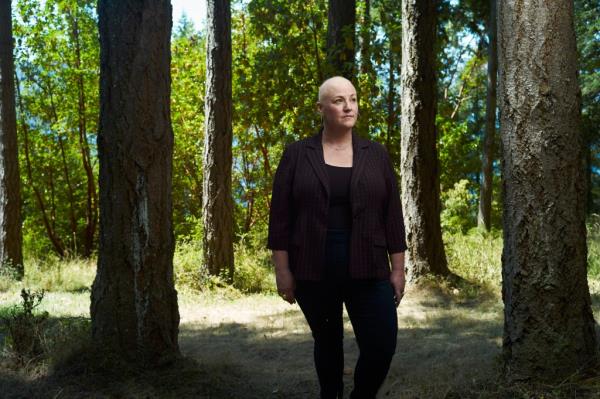 Amy Sousa standing in a forest in Port Townsend, reflecting on the co<em></em>ntrast between mastectomy and top surgery in social media posts