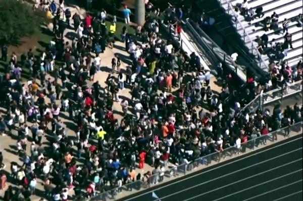 Apalachee High School students and staff outside the football field after getting evacuated for a school shooting on Sept. 4, 2024.