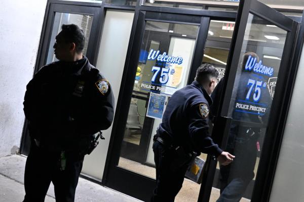 A photo of cops entering the 75th Precinct station house in East New York, Brooklyn.