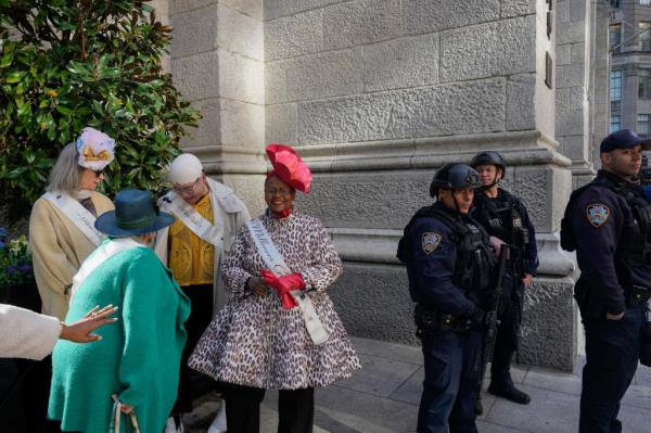 NYPD officers armed with rifles stand guard as revelers take part in  the annual Easter Parade and Bo<em></em>nnet festival outside St. Patrick's Cathedral.