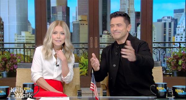 Kelly Ripa and Mark Co<em></em>nsuelos sitting a desk. 