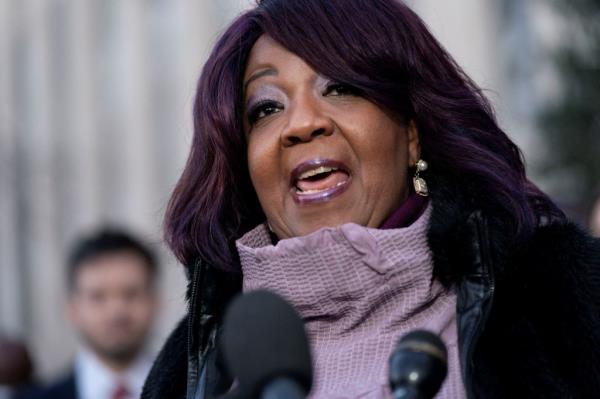 Ruby Freeman Moss, a Georgia election worker with purple hair, speaking into a microphone at a press co<em></em>nference after winning a defamation lawsuit against Rudy Giuliani