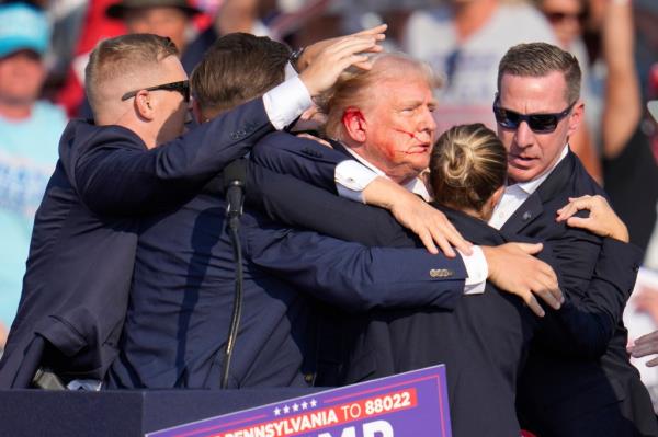 Former President Do<em></em>nald Trump surrounded by U.S. Secret Service agents at a campaign rally in Butler, Pa., 2024