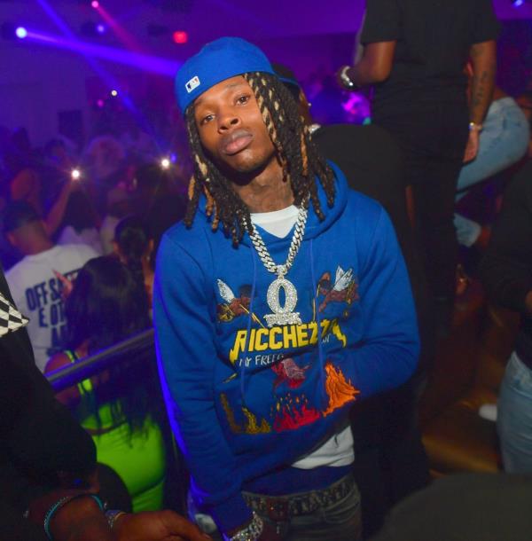 Rapper King Von in a blue hat and sweatshirt attending Compound Saturday Nights event with a crowd in the background