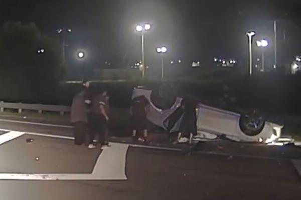 Footage shows Georgia police and bystanders lift an overturned car to rescue a trapped driver.
