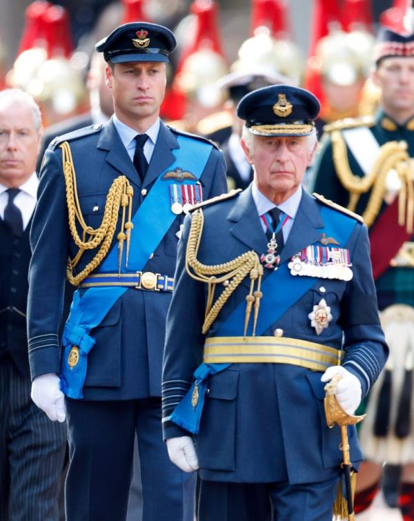 Prince Charles and Prince William walking solemnly behind Queen Elizabeth II's coffin carried on a gun carriage from Buckingham Palace to The Palace of Westminster.
