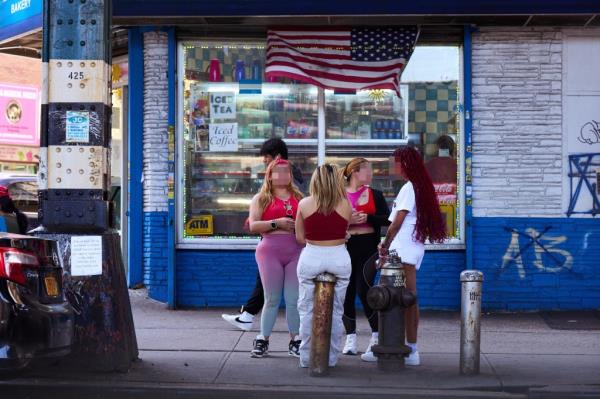 Women stand outside a store near the intersection of Elmhurst Avenue and Roosevelt Avenue on Monday, April 15, 2024 in Queens, New York.