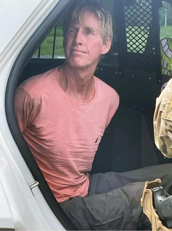 Suspected would-be assassin, Ryan Routh, sitting in a car after his arrest for allegedly targeting former President Trump on a golf course in Florida