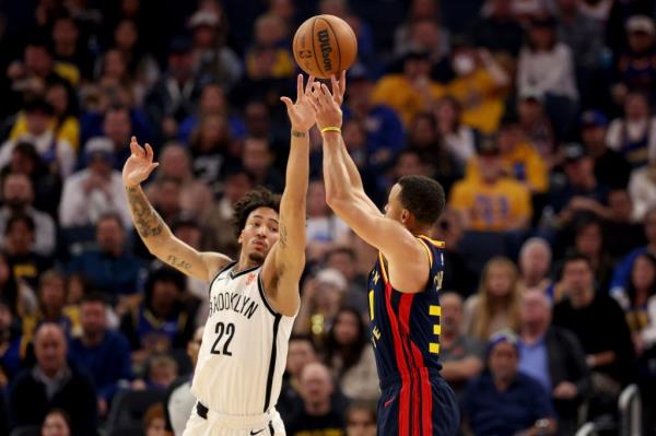 Golden State Warriors guard Stephen Curry, right, looks to shoot against Brooklyn Nets forward Jalen Wilson (22) during the first half of an NBA basketball game in San Francisco, Monday, Nov. 25, 2024.