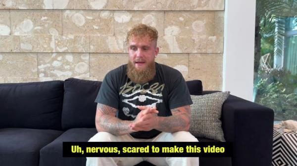 Jake Paul sitting on a black couch.