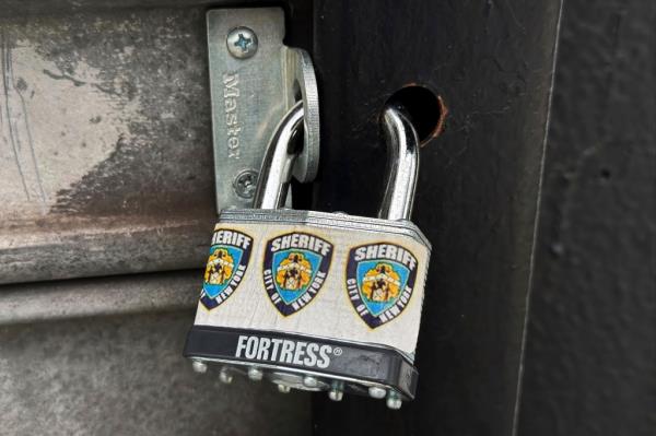 A New York City Sheriff's Department padlock secures Spark & Brew, an illegal cannabis shop, in the Queens borough of New York, Tuesday, July 23, 2024