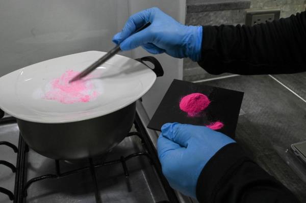 A man prepares a powder known as Tussi or pink cocaine in Medellin, Colombia, on April 2, 2022. - Three decades after Pablo Escobar's shot body was left on a Medellin rooftop, drug trafficking co<em></em>ntinues and, at present, markets for flavored cocaine, local crack, pharmaceutical drugs and ketamine-ba<em></em>sed hallucinogens are rife for in his hometown. (Photo by JOAQUIN SARMIENTO / AFP) (Photo by JOAQUIN SARMIENTO/AFP via Getty Images)