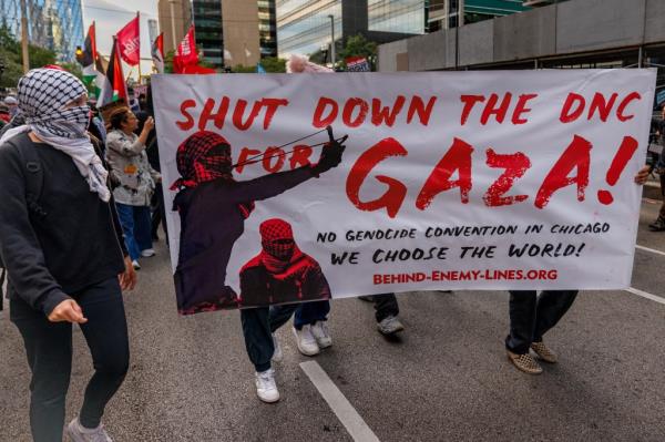 Protesters with a sign calling for the DNC to be 