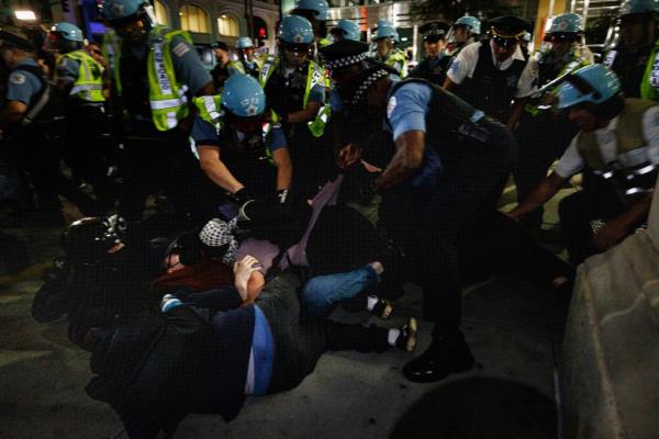 Chicago police officers holding protesters on the ground during the clash.