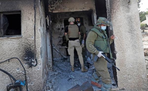 Israeli soldiers searched for the bodies of Israelis killed in Kfar Aza kibbutz near the border with Gaza, on Tuesday (Picture: EPA)