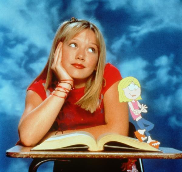 Hilary Duff as Lizzie McGuire sitting at a desk with a book, accompanied by her animated counterpart