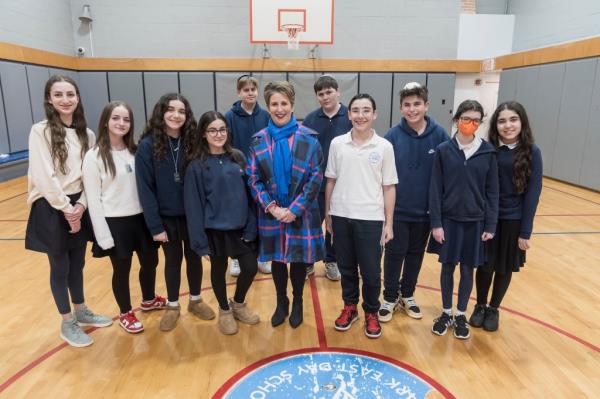 A private school building with a blue and beige facade, seen from across the street and its surrounding neighborhood.