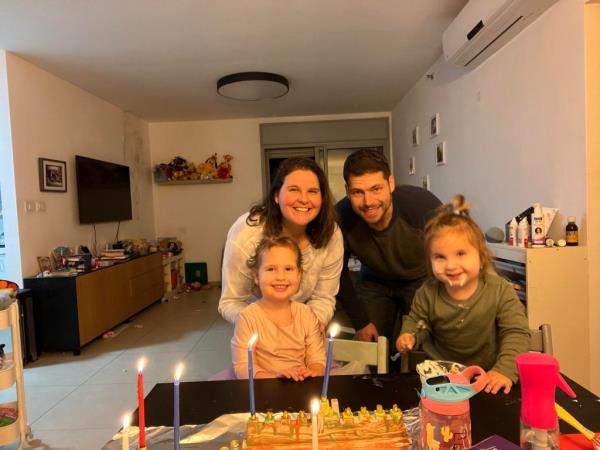 Stephanie Cramer, her husband, and their two daughters smiling for a photo.