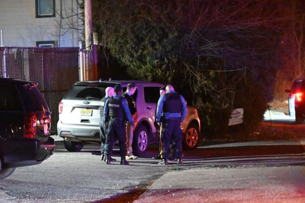 A group of police officers standing in front of a car on Columbia Street in Knowlton Township wher<em></em>e an active shooter was reported on 12 Feb 2024.