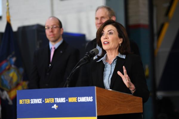 New York Governor Kathy Hochul at a podium announcing the unveiling of new subway cars, with MTA Chairman Janno Lieber, photo by Matthew McDermott
